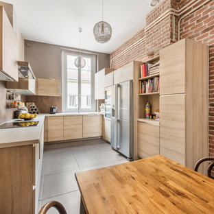 Cette photo montre une cuisine tendance en U fermée et de taille moyenne avec un plan de travail en stratifié, une crédence marron, un électroménager en acier inoxydable, aucun îlot, un placard à porte plane et des portes de placard en bois clair.