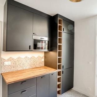 Mid-sized midcentury galley separate kitchen in Paris with a double-bowl sink, flat-panel cabinets, black cabinets, concrete benchtops, multi-coloured splashback, porcelain splashback, panelled appliances, ceramic floors, no island, multi-coloured floor and green benchtop.