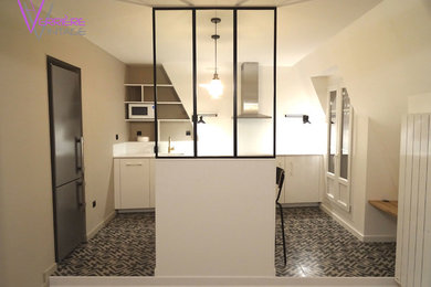 Bild på ett mellanstort industriellt vit vitt kök med öppen planlösning, med en undermonterad diskho, luckor med profilerade fronter, vita skåp, vitt stänkskydd, integrerade vitvaror, klinkergolv i keramik och flerfärgat golv