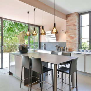 Inspiration pour une cuisine nordique avec un évier 3 bacs, un placard à porte plane, des portes de placard blanches, une crédence grise, un îlot central, un sol beige et un plan de travail gris.
