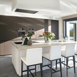 Aménagement d'une grand cuisine contemporaine avec un placard à porte plane, des portes de placard marrons, un électroménager de couleur, un îlot central et un plan de travail en bois.