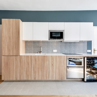 Inspiration for a mid-sized scandinavian single-wall open plan kitchen in Paris with an undermount sink, light wood cabinets, blue splashback, ceramic splashback, stainless steel appliances, ceramic floors and no island.