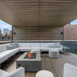 Ispirazione per una terrazza minimal sul tetto e sul tetto con un focolare e una pergola