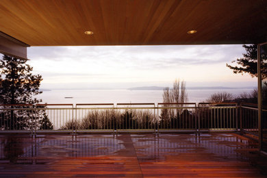 Example of a minimalist deck design in Seattle with a roof extension