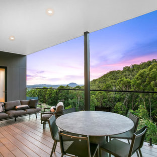 Contemporary backyard deck in Sunshine Coast with a roof extension.