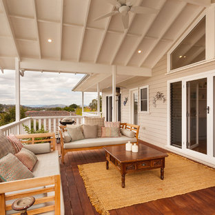 Mid-sized beach style rooftop and first floor deck in Other with a roof extension.
