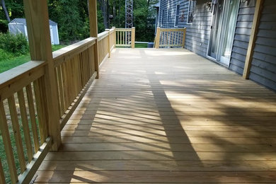 Inspiration for a large timeless backyard deck remodel in Other with a roof extension