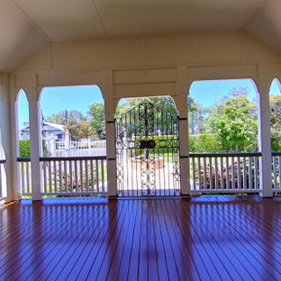 Exemple d'une grande terrasse latérale chic avec des solutions pour vis-à-vis et une extension de toiture.