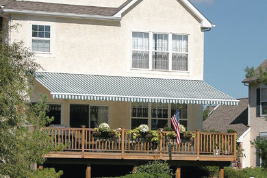 Example of a backyard deck design in Boston with an awning