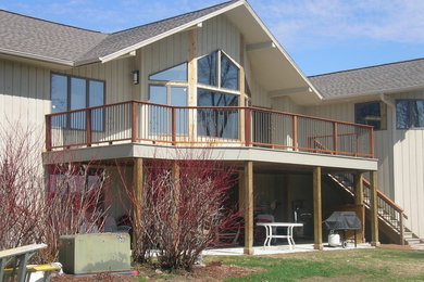 Example of a large backyard deck design in Other with a roof extension
