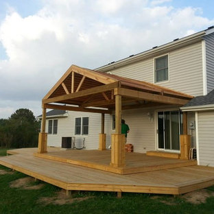 Huge arts and crafts backyard deck photo in Indianapolis with a roof extension