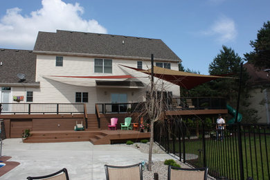 Modelo de terraza clásica grande en patio trasero con cocina exterior y toldo