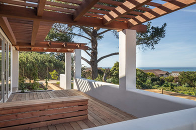 Diseño de terraza costera de tamaño medio en patio lateral con pérgola