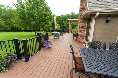 Example of a large classic backyard deck container garden design in Kansas City with a pergola