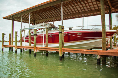 Inspiration for a large coastal backyard dock remodel in Tampa with a roof extension