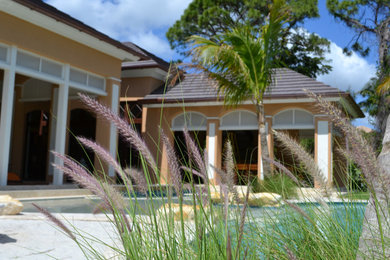 Large tuscan backyard deck photo in Miami with no cover