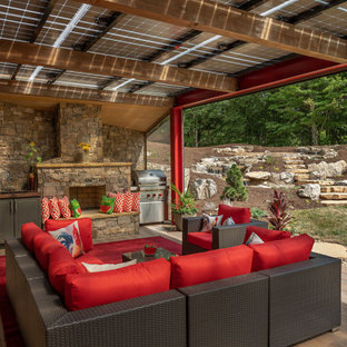 Ispirazione per una grande terrazza minimal dietro casa con un caminetto e una pergola