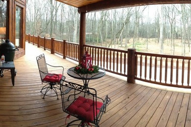 Example of a large arts and crafts backyard deck design in Atlanta with a roof extension