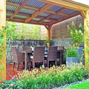 Example of a trendy backyard deck container garden design in New York with a pergola