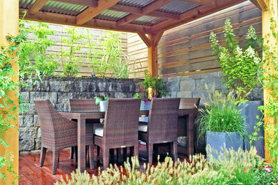 Example of a trendy backyard deck design in New York with a pergola