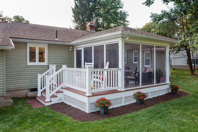 Example of a mid-sized classic backyard deck design in Boston with a roof extension