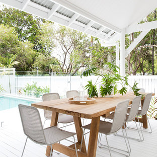 This is an example of a beach style deck in Brisbane with a roof extension.