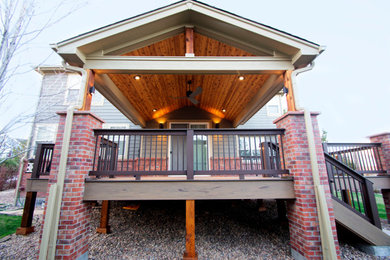 Inspiration for a mid-sized transitional backyard deck remodel in Denver with a roof extension