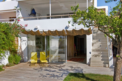 Diseño de terraza mediterránea de tamaño medio en patio trasero con toldo