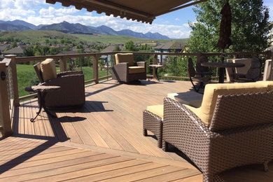 Large contemporary back terrace in Denver with an awning.