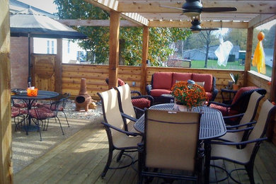 Ejemplo de terraza de estilo americano de tamaño medio en patio lateral con pérgola