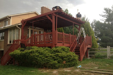 Inspiration for a large rustic deck remodel in Denver with a pergola