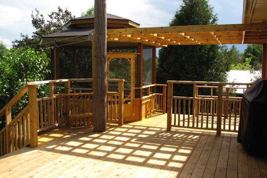 Example of a large classic backyard deck design in Toronto with a pergola