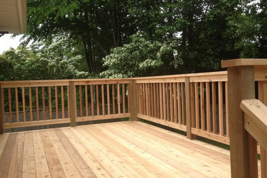 Example of a large backyard deck design in Vancouver with a pergola