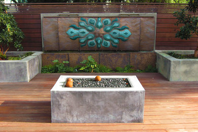This is an example of a large modern back terrace in San Francisco with a fire feature and no cover.
