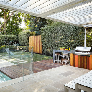 This is an example of a contemporary backyard deck in Sydney with a pergola.