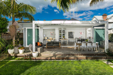 Cette image montre une terrasse arrière marine avec une cuisine d'été et une pergola.
