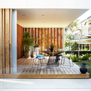 Example of a mid-sized trendy courtyard deck design in Sydney with a pergola