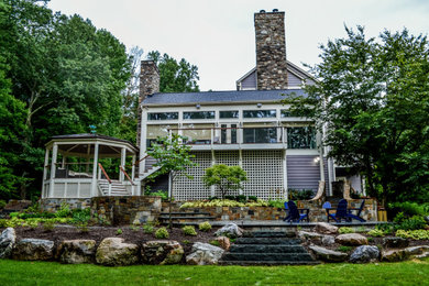 Cette photo montre une grande terrasse arrière tendance avec un foyer extérieur.