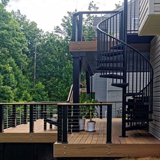 Immagine di una grande terrazza design dietro casa con un parasole