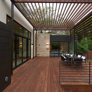 Ispirazione per una grande terrazza minimal dietro casa con una pergola