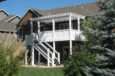 Inspiration for a large timeless backyard deck remodel in Kansas City with a pergola