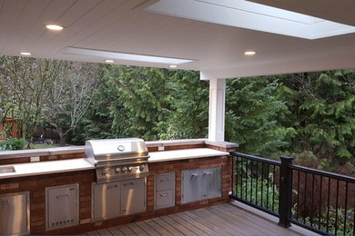Mid-sized trendy backyard outdoor kitchen deck photo in Seattle with a roof extension
