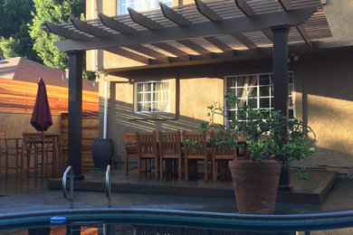 Example of a large classic backyard deck container garden design in Los Angeles with a pergola