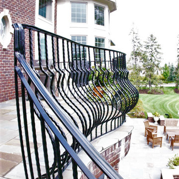 Curved Exterior Staircase with Wrought Iron Balcony Rail