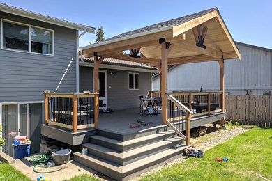 Large transitional backyard deck photo in Seattle with a pergola