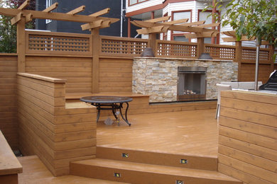 Mid-sized trendy backyard deck photo in Calgary with a fire pit and a pergola
