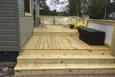 Mid-sized elegant backyard deck photo in Other with no cover