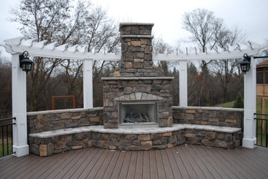 Example of a mid-sized classic backyard deck design in Minneapolis with a fireplace and no cover
