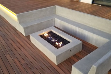 Diseño de terraza minimalista de tamaño medio sin cubierta en patio trasero con brasero