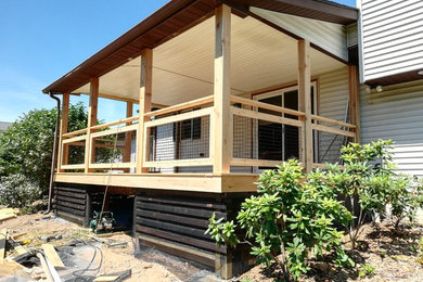 Diseño de terraza de estilo americano grande en patio trasero y anexo de casas